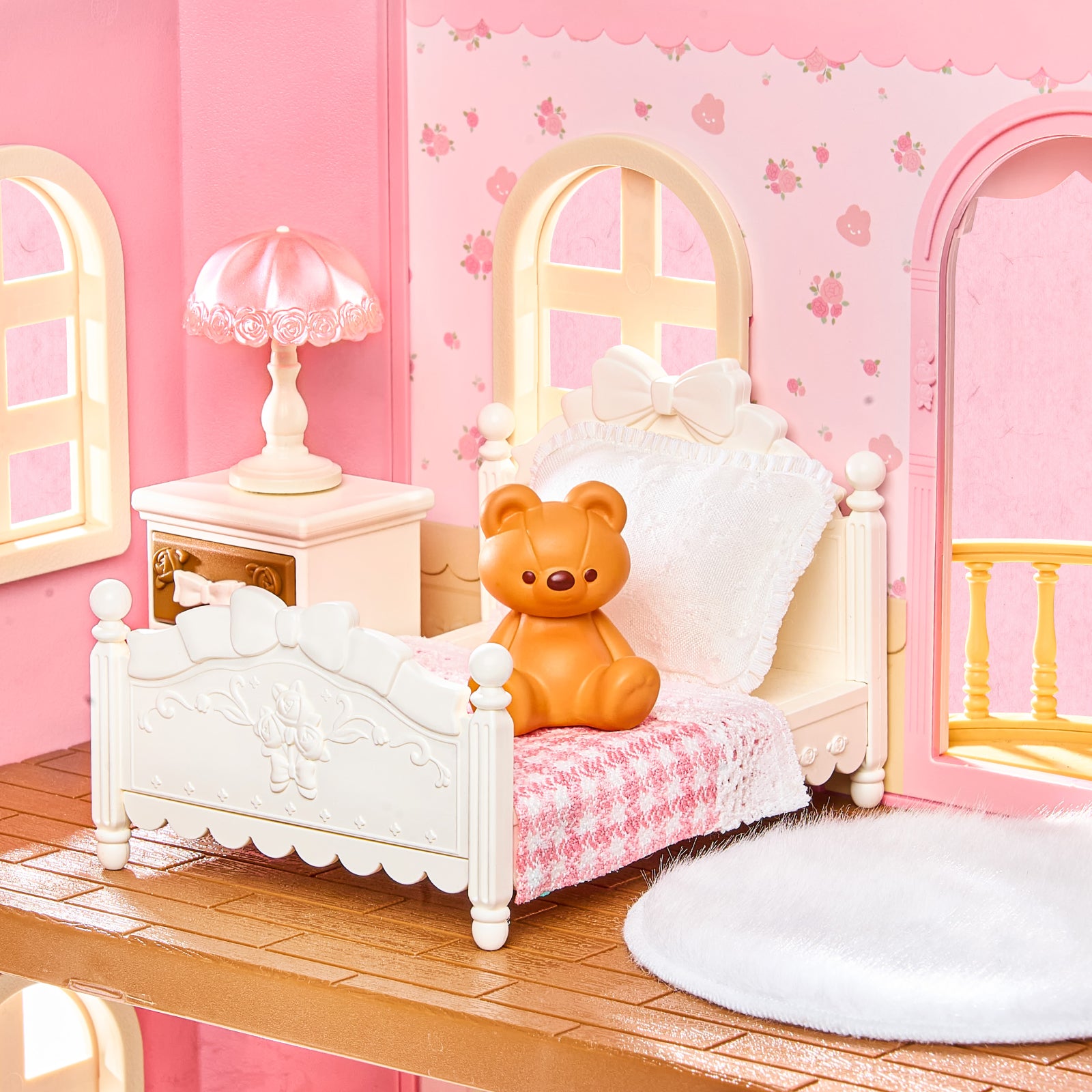 Détail de la chambre Rolife Fairy Rose Cottage HH001 avec lit blanc, ours en peluche, lampe et murs roses.