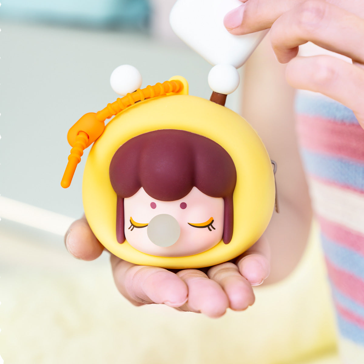 étui pour écouteurs abeille jaune Baby Nanci Fluffy Party tenu à la main