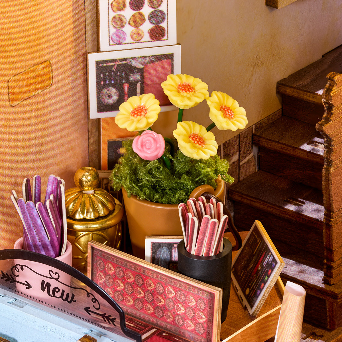 Gros plan de fleurs miniatures, de gobelets à stylos et de détails de papeterie à l'intérieur du Book Nook Wisdom Stationery Shop