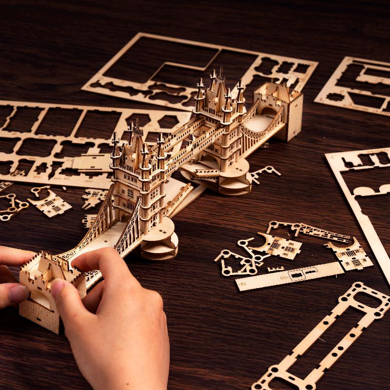 Hände, die das Rolife Tower Bridge TG412 Holzpuzzle aus Brettstücken zusammensetzen