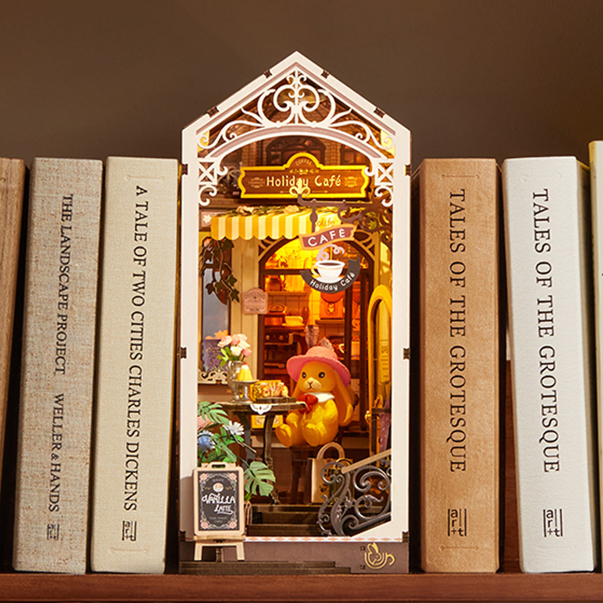 Holiday Cafe TGB15 Regaldisplay zwischen Büchern mit warmer Innenbeleuchtung