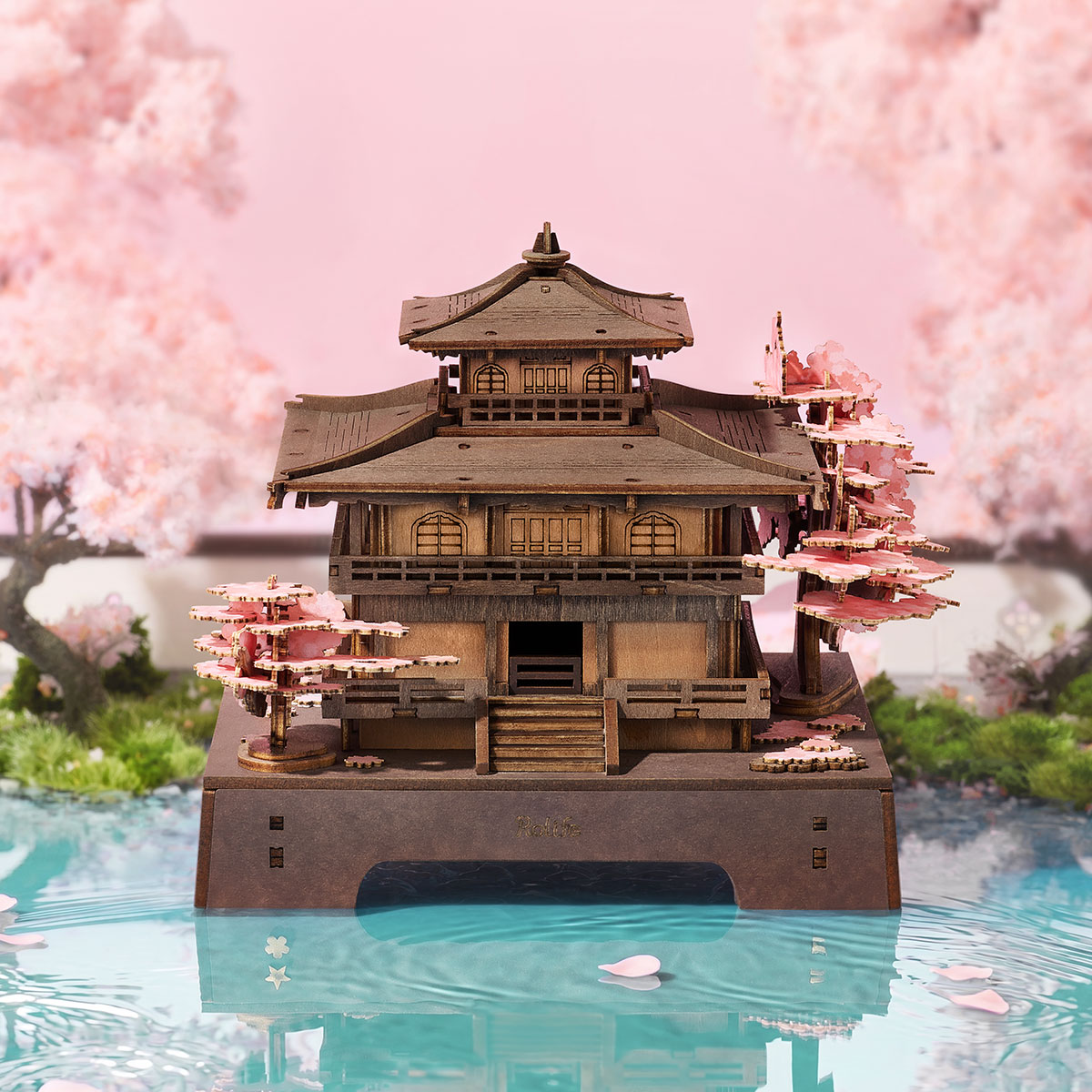 Rolife Sakura Pavilion Holzpuzzle neben Kirschblüten und reflektierendem Wasser