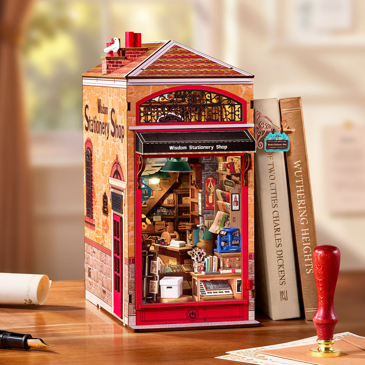 Rolife Wisdom Stationery Shop DIY Book Nook auf einem Schreibtisch neben Büchern ausgestellt