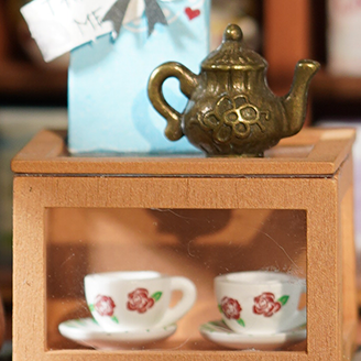 Alice's Tea Store DG156 Teekanne und Teetasse, Regaldetail, Nahaufnahme.