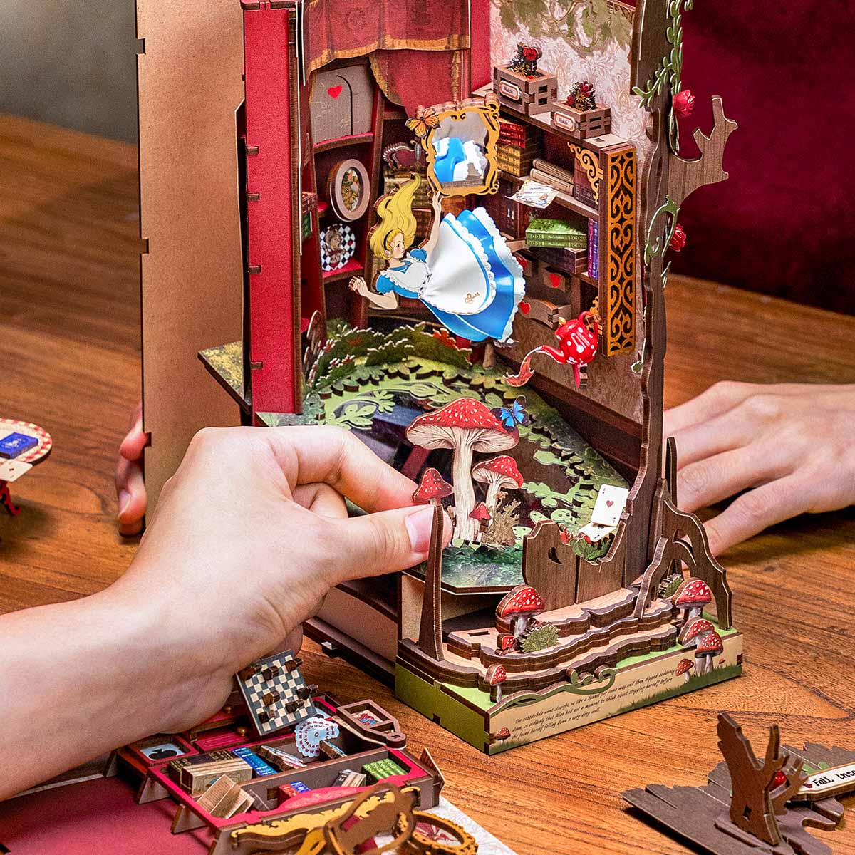 Hände bauen die Buchecken-Szene „Fall into Wonder TGB12“ zusammen.
