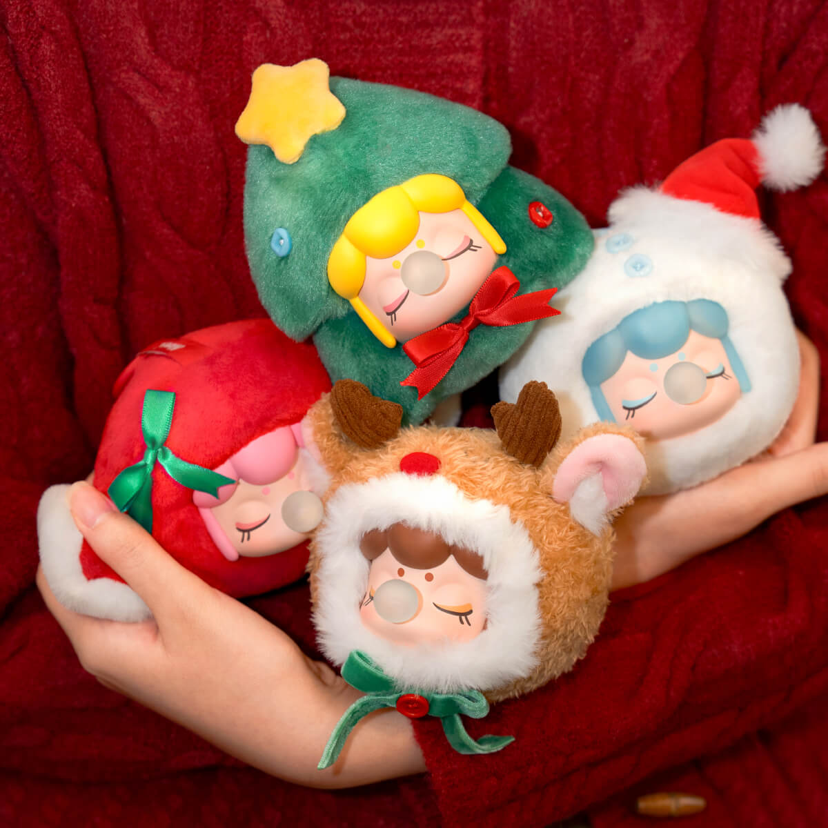 Nanci Christmas Gift-collectie van drie feestelijke pluchen hangers die in de handen worden gehouden