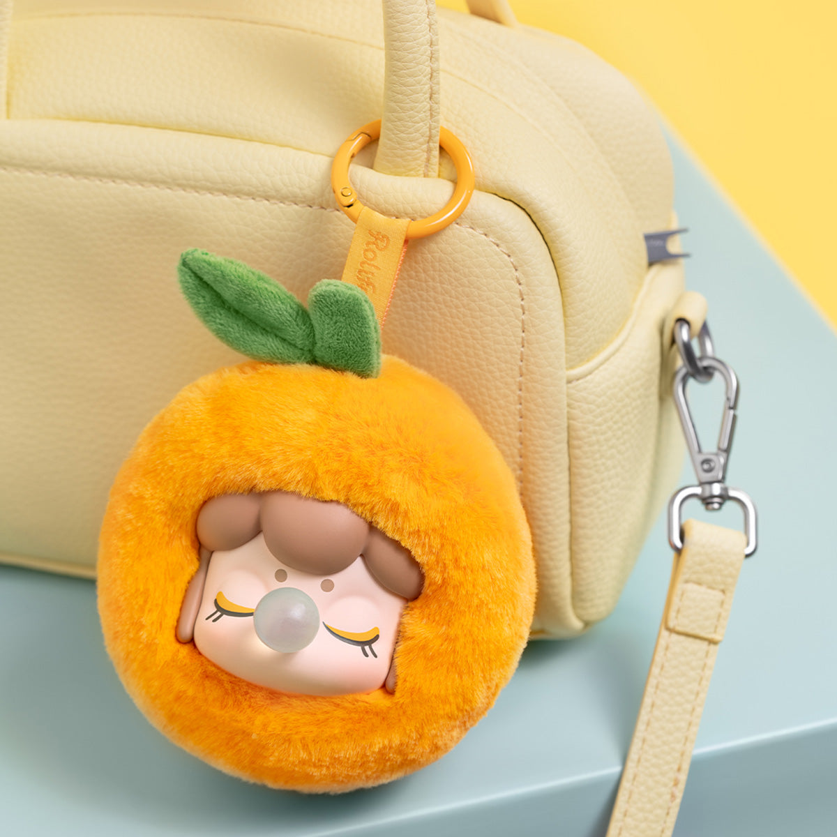 Nanci Fruit Mood Oranje pluche hanger hangend aan een handtas