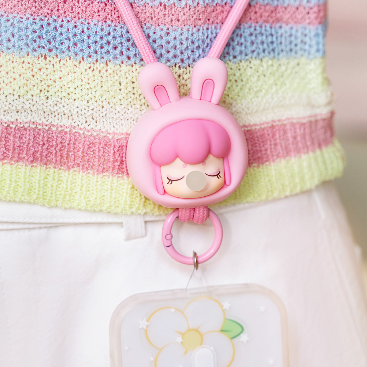 Baby Nanci Fluffy Party roze konijntje telefoonketting hangend aan een gestreepte tas