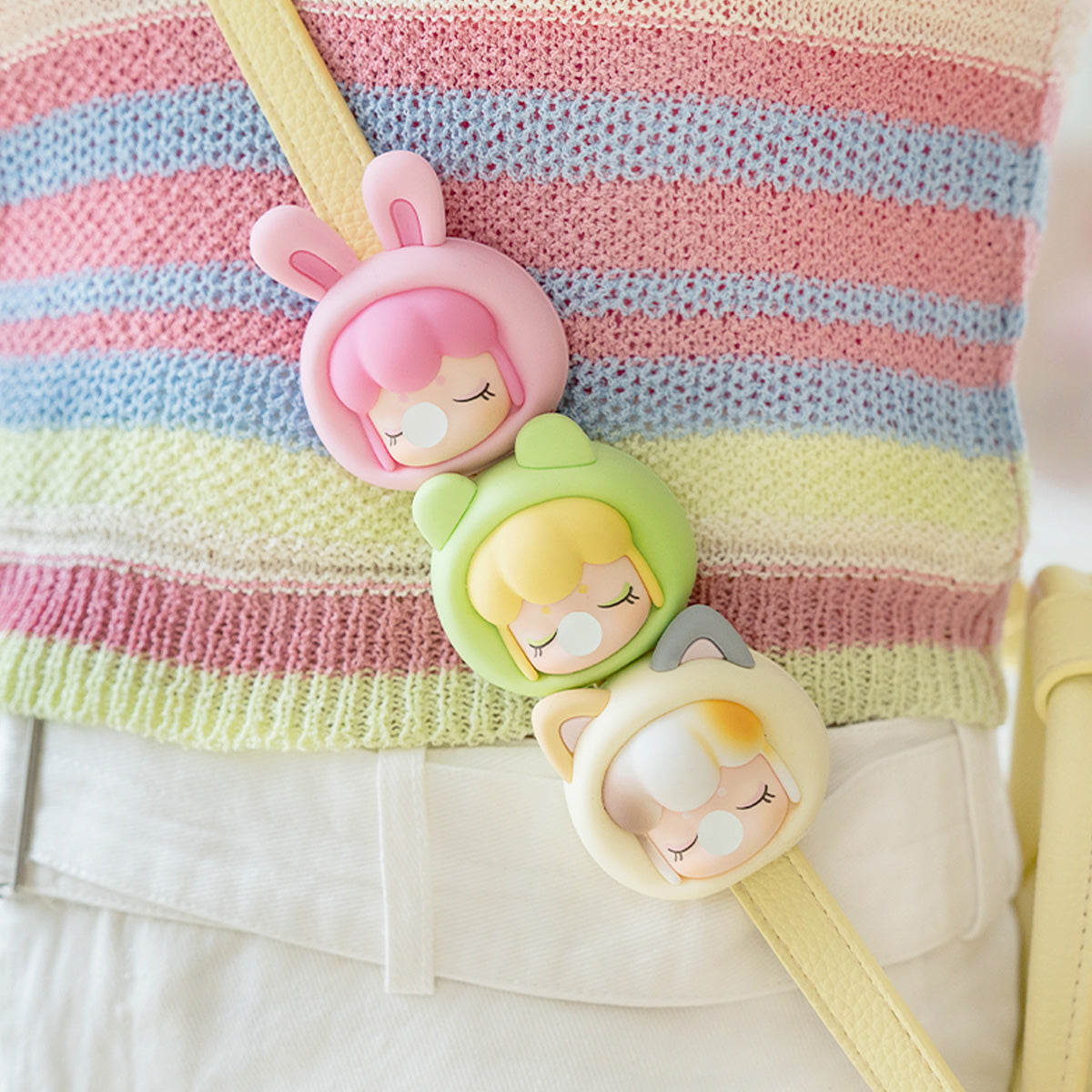 Baby Nanci Fluffy Party drie telefoonkettingen die aan een gestreepte tas hangen