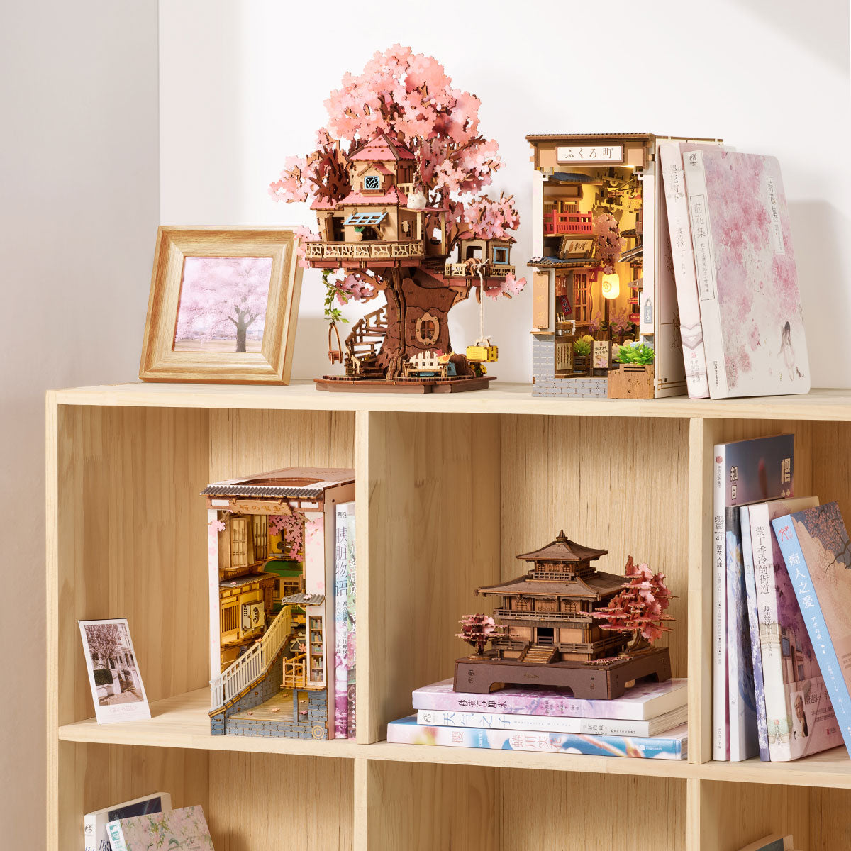 Rolife Sakura Paviljoen weergegeven op een boekenplank met boeken en andere miniatuurhuismodellen