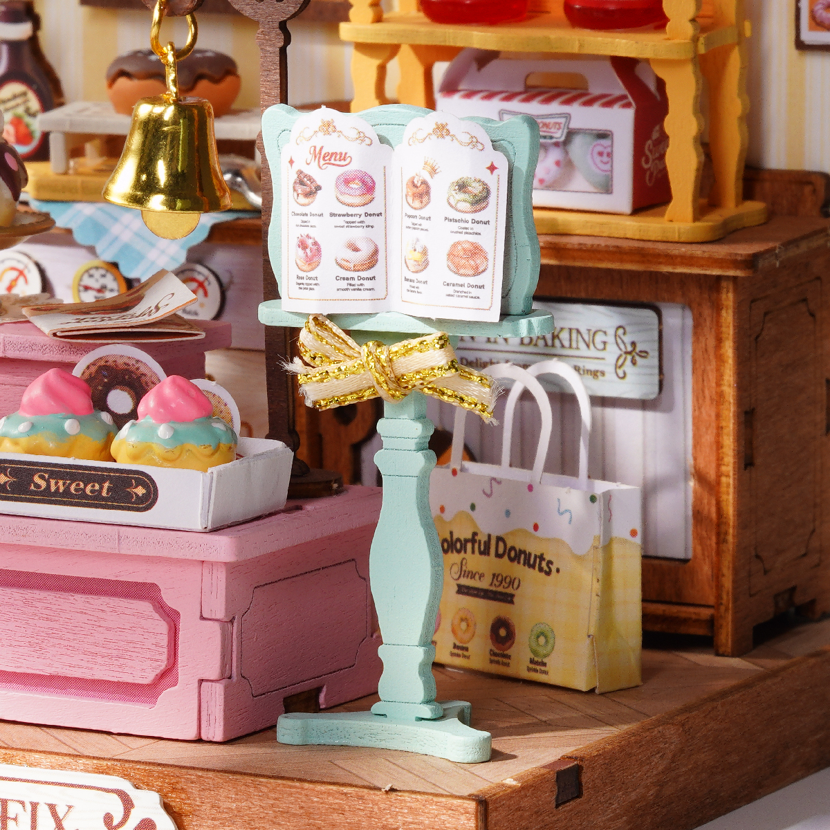 Close-up van Sweetie's Donut Shop-oven, menustandaard, drankjes en bakkerijplanken