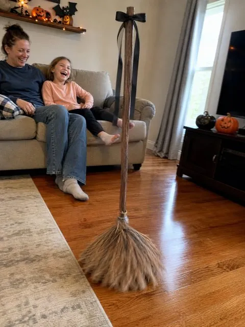 Family laughing as the animated broom moves