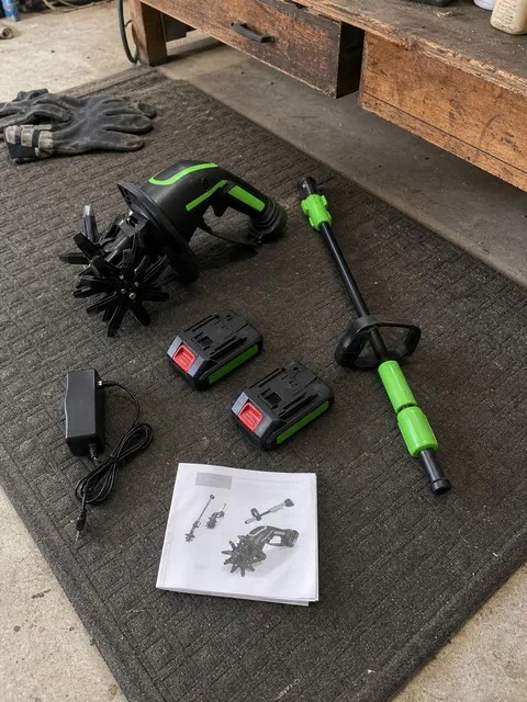 Cordless tiller kit with extension pole, two batteries, charger, and manual