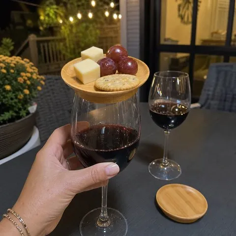 Customer using a bamboo wine glass topper on a patio