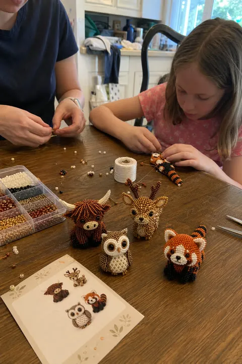 Parent and child crafting beaded animals together at a table