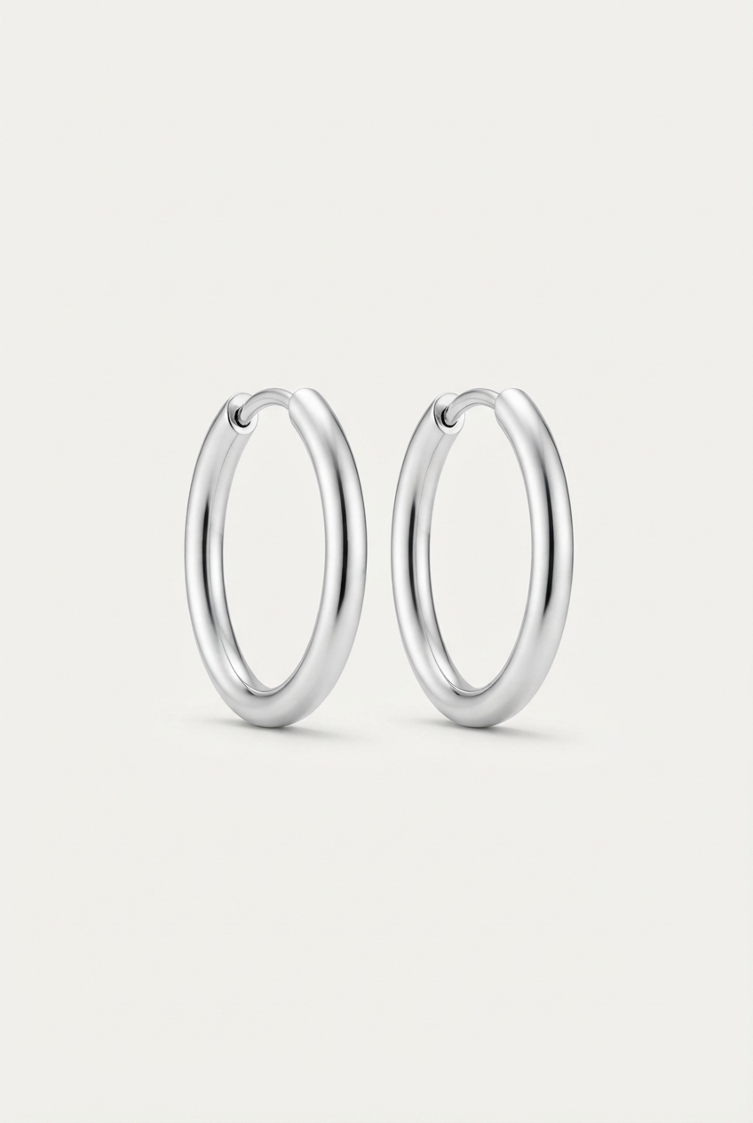 Silver smooth hoop earrings on matte background.