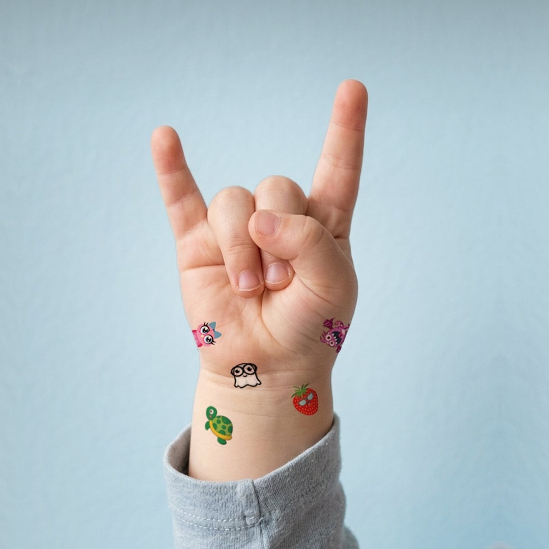 Kid throwing up a rock-on hand sign with Brandage temporary tattoos on their wrist