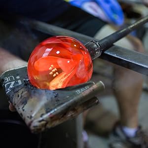 Close-up sequence showing melted glass being shaped and formed while glowing bright orange-red hot, demonstrating traditional glassblowing techniques.