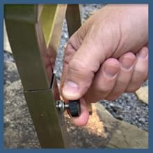 Hand tightening an adjustment knob on an outdoor fryer.