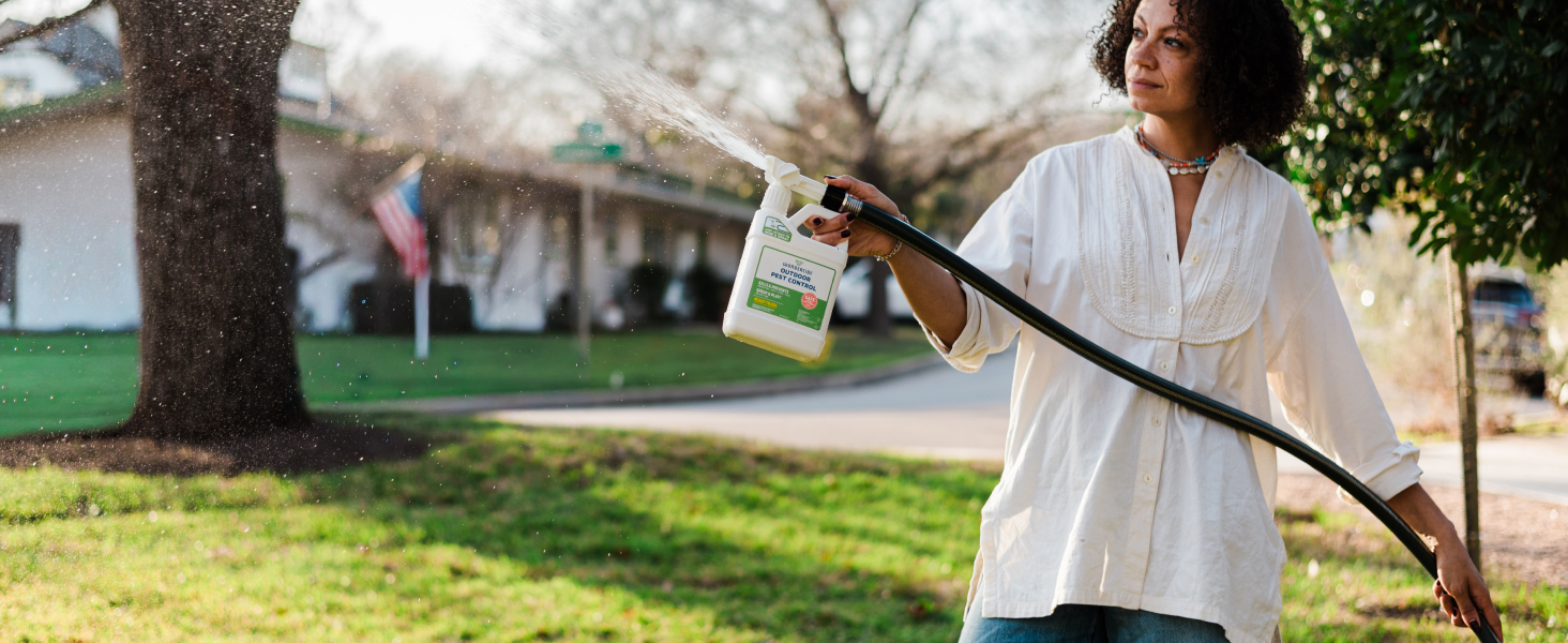A person spraying Wondercide in their yard