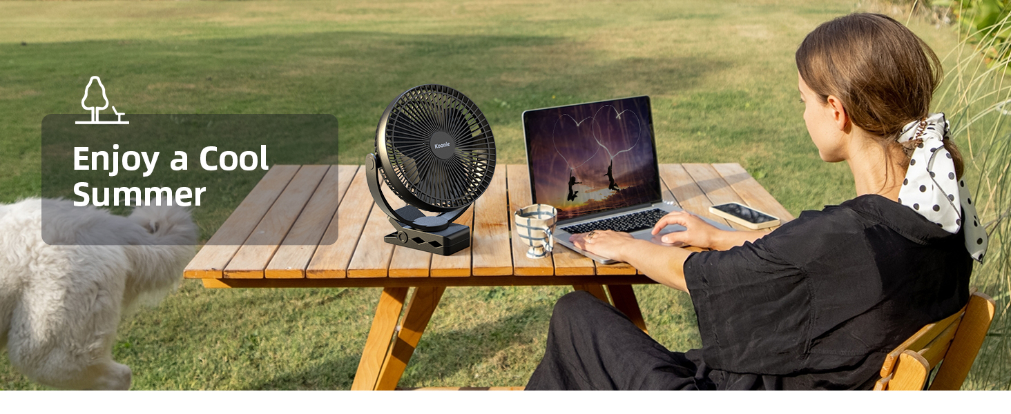 Outdoor workspace setup with laptop and portable black fan on wooden picnic table, with text overlay reading 'Enjoy a Cool Summer'