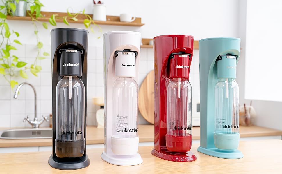 Four carbonated water makers in different colors (black, white, red, and blue) displayed on kitchen counter, featuring sleek modern design with clear bottles.
