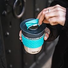 a woman holding a coffee cup in her hand.