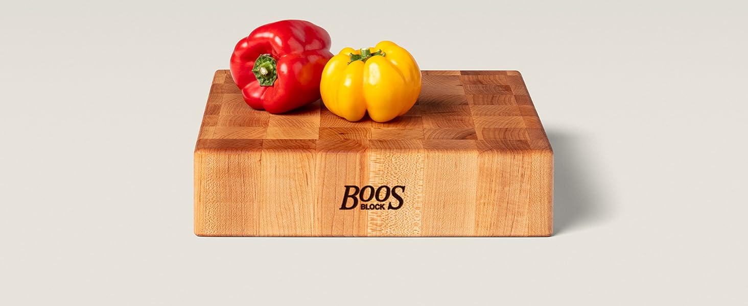 Peppers on a wooden chopping block on light background.