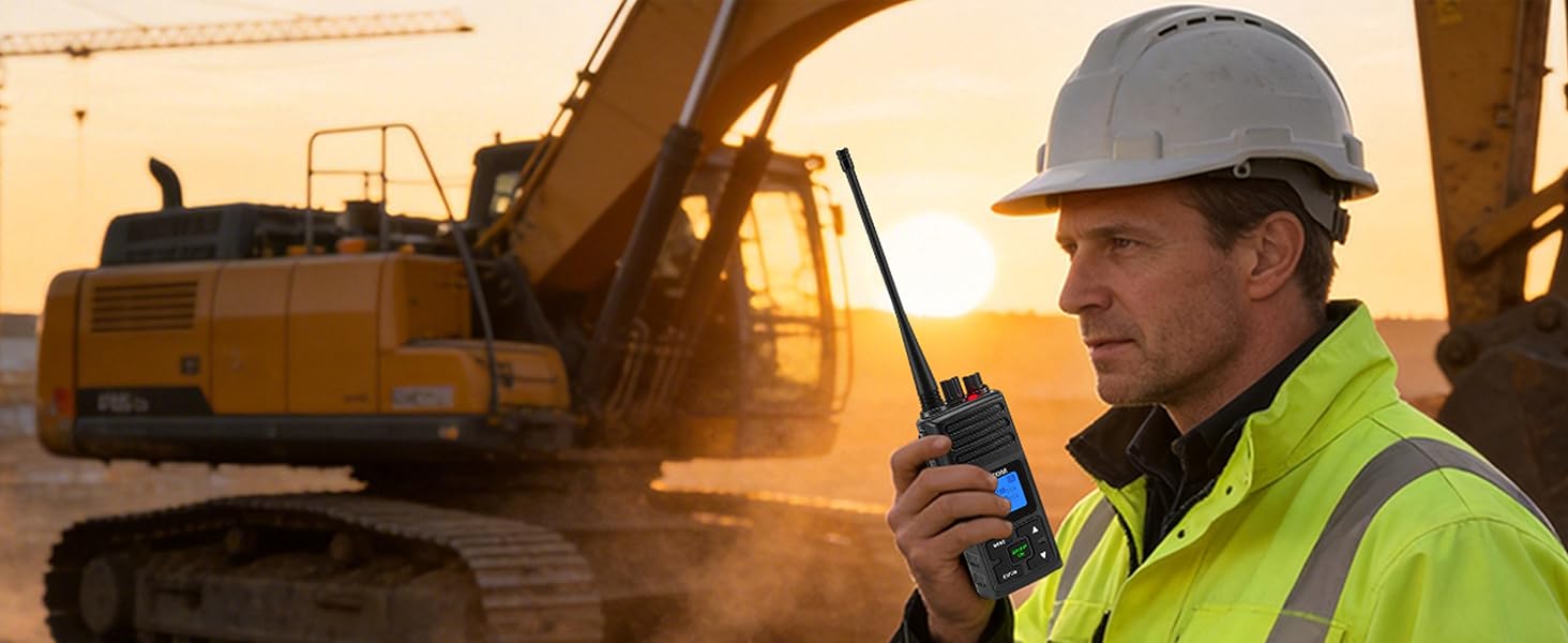 A rugged construction foreman in a hi-vis jacket and hard hat grips a walkie-talkie while standing