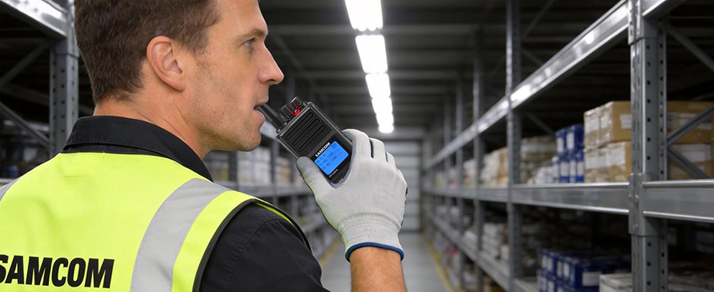 A warehouse team leader in a safety vest and gloves speaks into a walkie-talkie