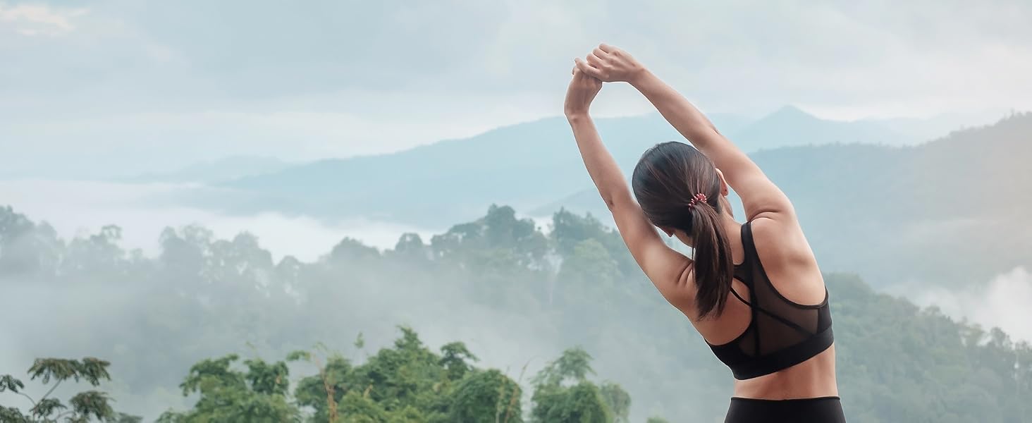 BulkSupplements Magnesium Glycinate Benefits Woman Stretching in the foggy mountains