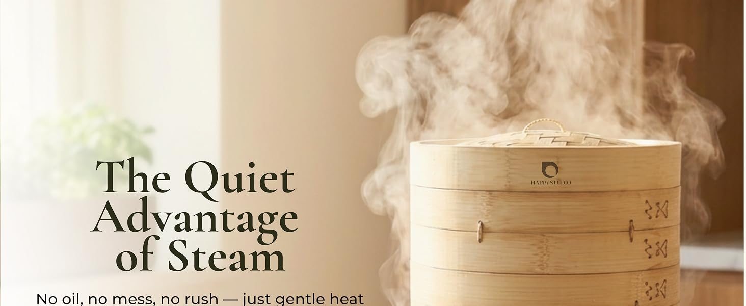 Stacked bamboo steamer tiers on a stainless pot, steam rising, Happi Studio logo on band