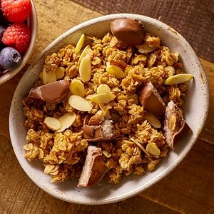 A bowl of granola topped with chopped up pieces of Almond Joy bars
