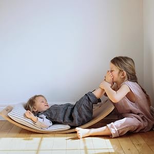 kinderfeets kinderboard toddler lying on top child playing wooden floor indoors white wall
