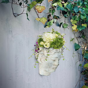 goddess planter on wall with foliage around