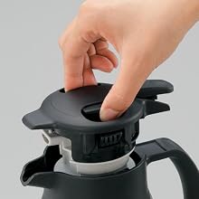 a hand removes the stopper by pinching the top
