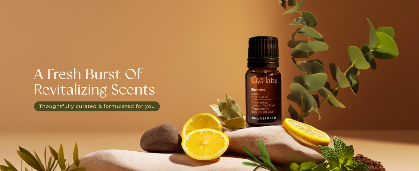 Essential oil bottle on wooden surface with citrus fruits, stones, and eucalyptus leaves. Text describes 'fresh burst of revitalizing scents'.