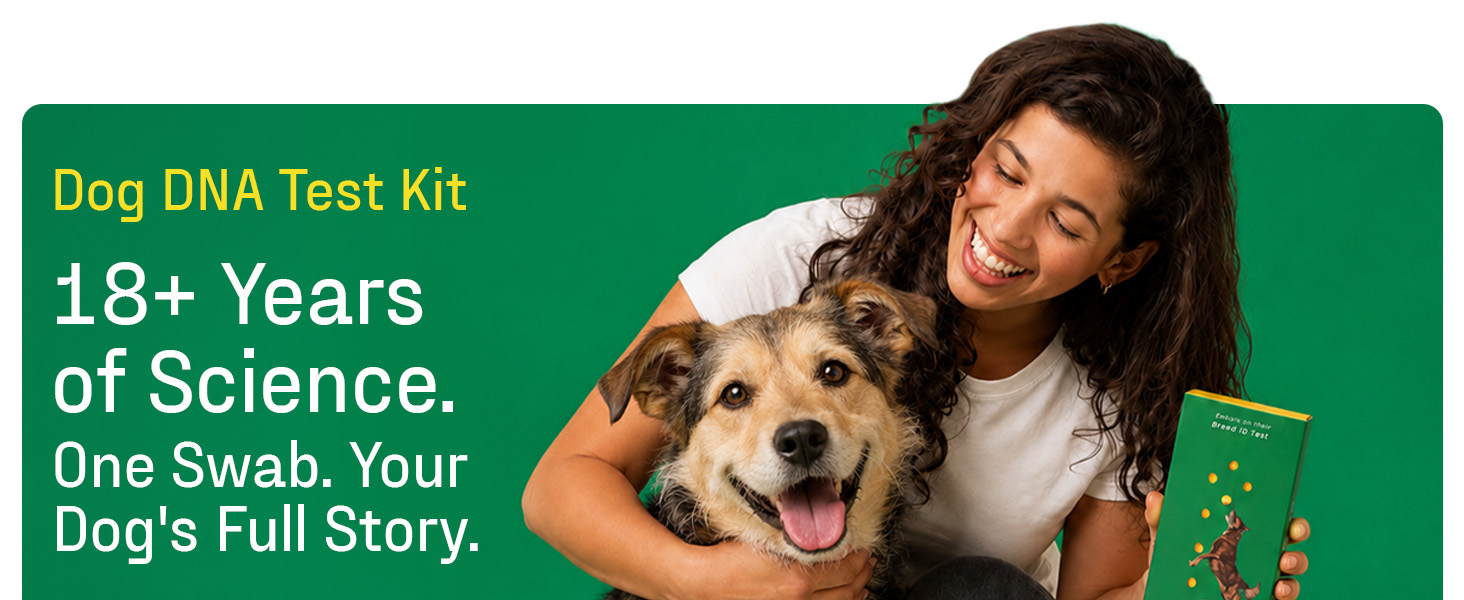 Smiling woman hugging a happy mixed breed dog while holding a green DNA My Dog breed test kit box.