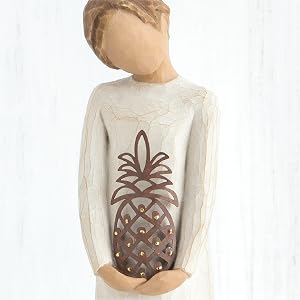 Close up detail of figure holding metal pineapple.