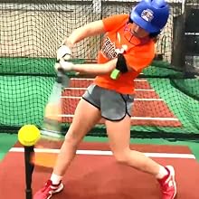 girl softball player hitting ball off tee using swingrail in batting cage