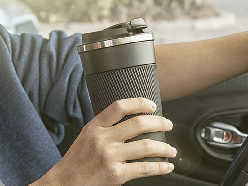 a person holding a coffee cup in their hand.