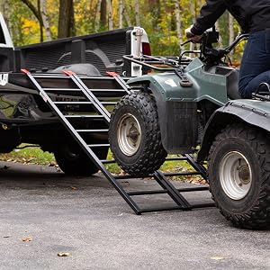 Person riding ATV up ST-TF-7449-V2 tri-fold ramp into pickup truck bed