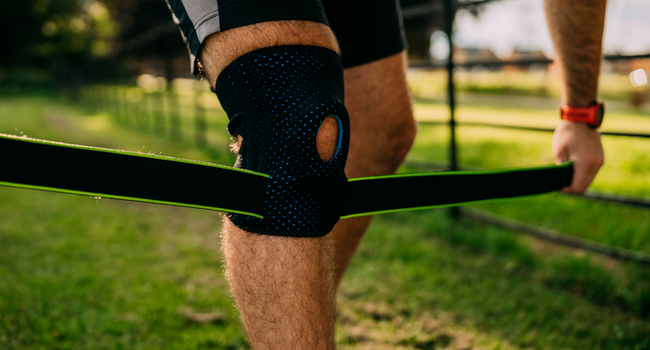 Man stading adjusting the straps of the Knee Brace with Side Stabilizers