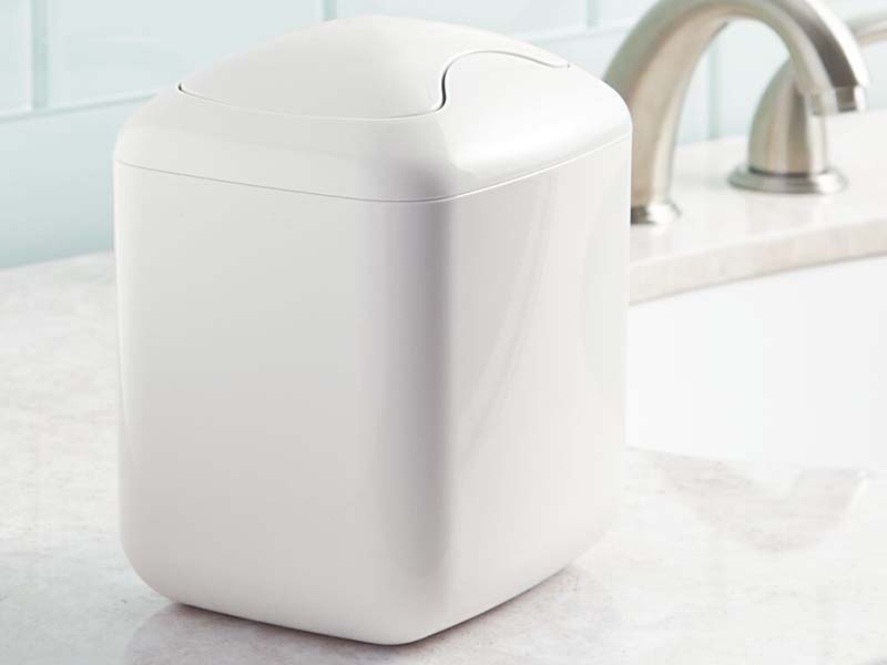 vanity waste can with swing top lid in white on top of bathroom vanity countertop