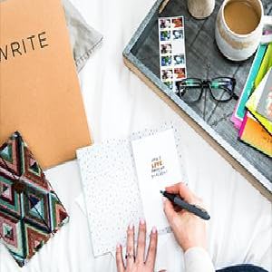 sitting on a bed writing inside a card