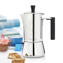 a stainless steel coffee maker with a cup of coffee and a cake on a table.