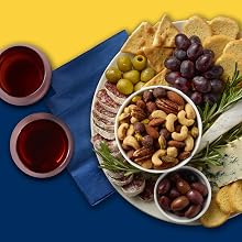 charcuterie tray with mixed nuts, grapes, olives, crackers, and cheese