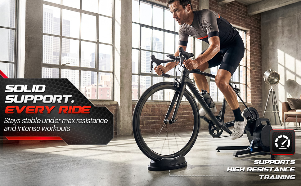 Cyclist riding hard on an indoor bike trainer with a front wheel stand for bike trainer supporting.