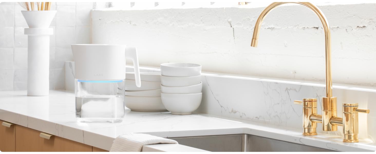 kitchen sink featuring a gold faucet atop a white counter, highlighting modern design and elegance.
