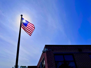 American flag at a business/school – outdoor community flag display inground pole by Fine Line Flag